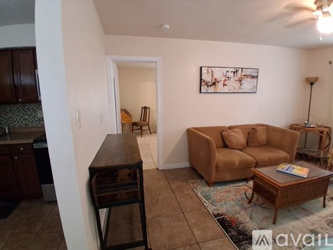 A living room with a brown couch and a wooden table.