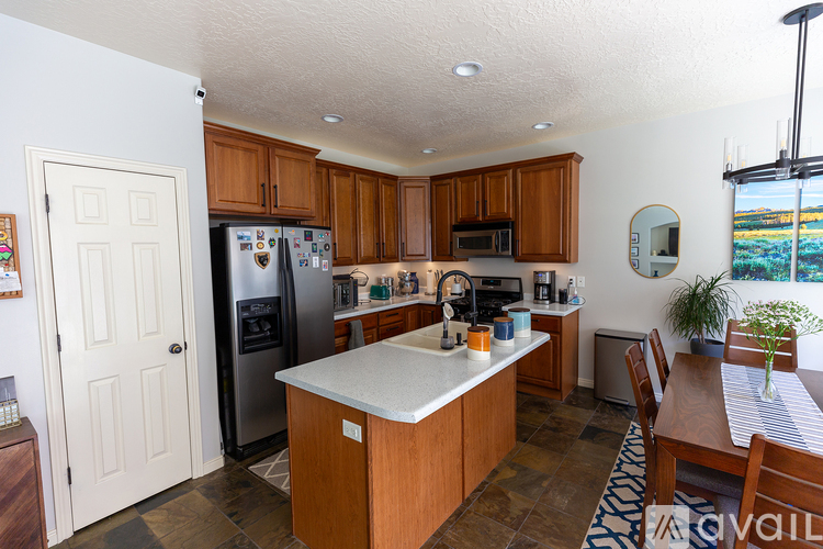 A kitchen with wooden cabinets and a white island.
