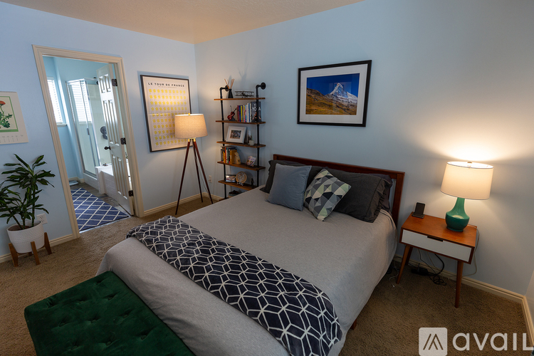 A bedroom with a bed, nightstand, and a lamp.