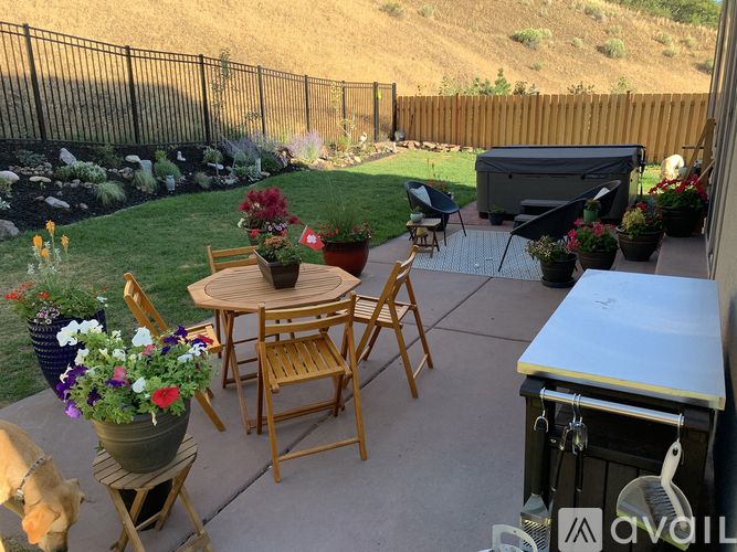 A patio with a table, chairs, and a hot tub.
