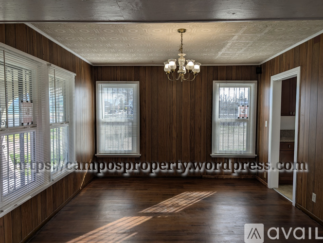 A room with wooden walls and a chandelier hanging from the ceiling.