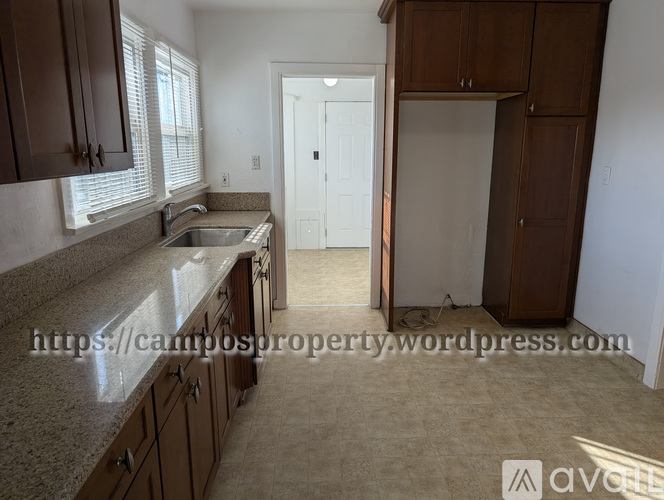 A kitchen with brown cabinets and a white door in the background.