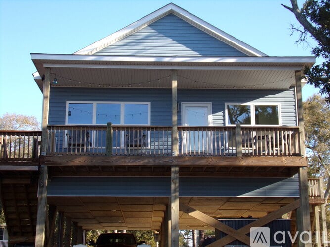 A wooden house with a balcony and a balcony railing.