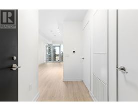 A hallway with a black door on the left and a white door on the right.