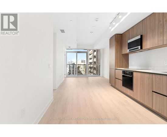 A spacious kitchen with wooden cabinets and a microwave on top.