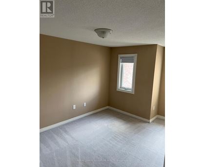 A room with a window and a carpeted floor.