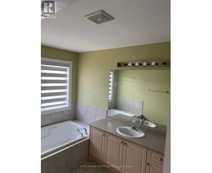 A bathroom with a tub, sink, and mirror.