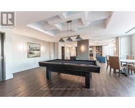 A pool table in a well lit room with a light wood floor.
