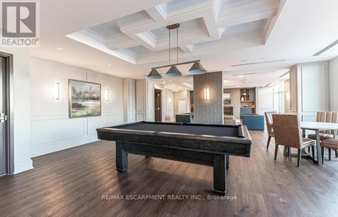 A pool table in a well lit room with a light wood floor.