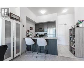 A modern kitchen with a bar area and two stools.