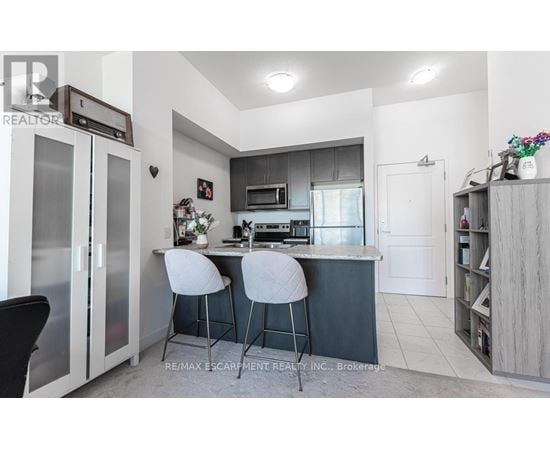 A modern kitchen with a bar area and two stools.