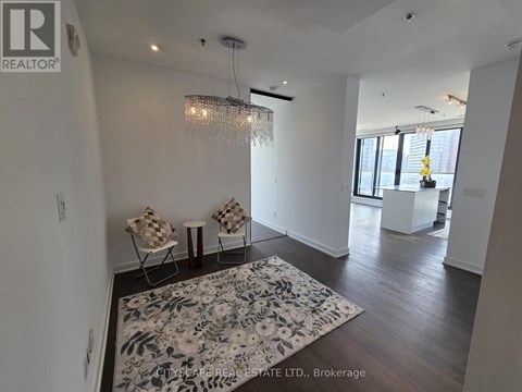 A living room with a rug and chairs.