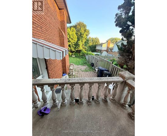 A balcony with a railing and a purple object on the ground.