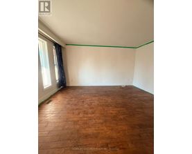 A room with wooden flooring and white walls.