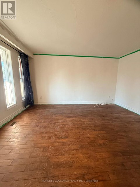 A room with wooden flooring and white walls.