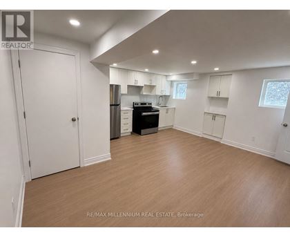 A spacious kitchen with white cabinets and a black stove top oven.