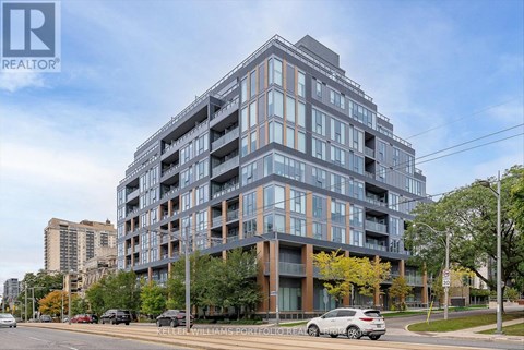 A modern multi-story building with a glass facade is the main focus of the image.