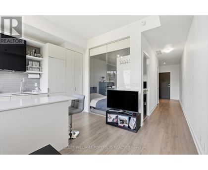 A modern bedroom with a large bed and a flat screen TV.