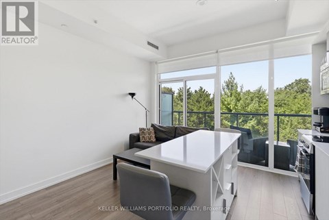 A well-lit, modern dining room with a glass table and chairs.