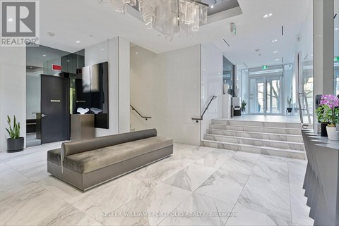A spacious lobby with a marble floor and a staircase leading to the second floor.