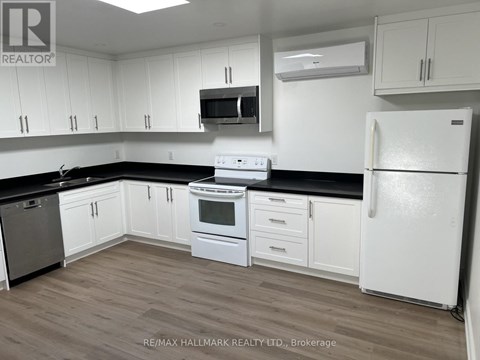 A kitchen with white cabinets and a white fridge.