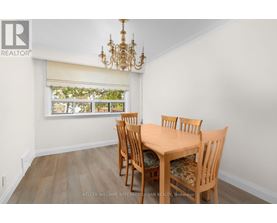 A dining room with a wooden table and chairs.