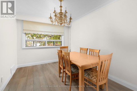A dining room with a wooden table and chairs.