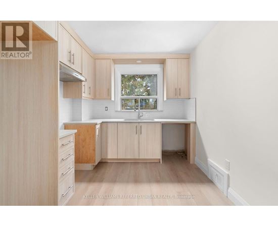 A kitchen with wooden cabinets and a window.