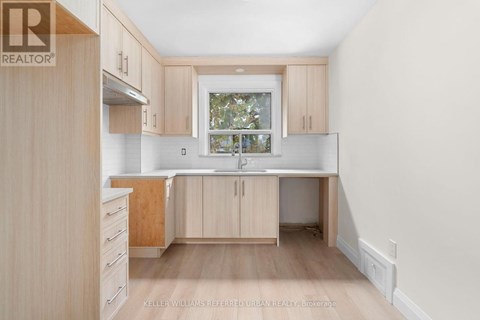 A kitchen with wooden cabinets and a window.