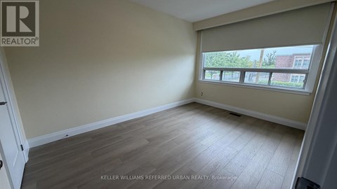 A room with a window showing a view of a building outside.