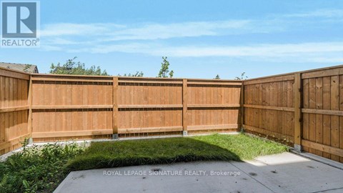 A backyard with a wooden fence and a grassy area.
