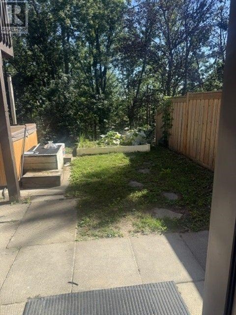 A backyard with a wooden fence and a small garden.