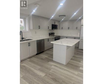 A kitchen with white cabinets and a white island.