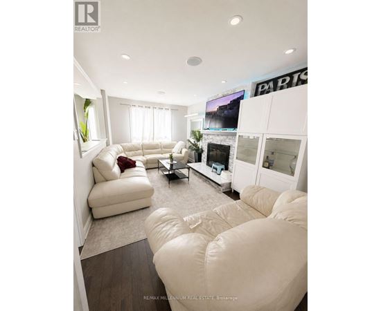 A living room with white furniture and a flat screen TV.