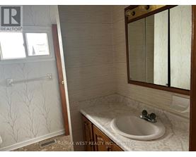 A bathroom with a sink, mirror, and shower.