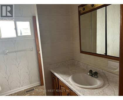 A bathroom with a sink, mirror, and shower.