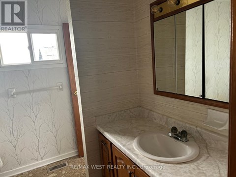A bathroom with a sink, mirror, and shower.