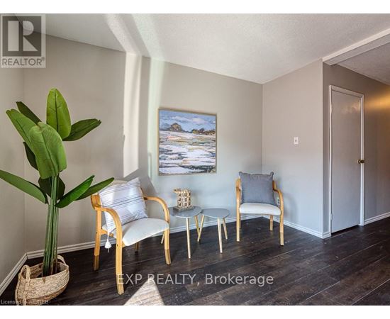 A living room with a painting of a beach scene on the wall.