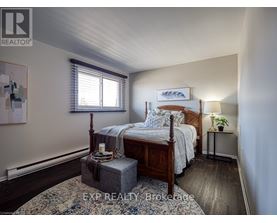 A bedroom with a bed, nightstand, and window.
