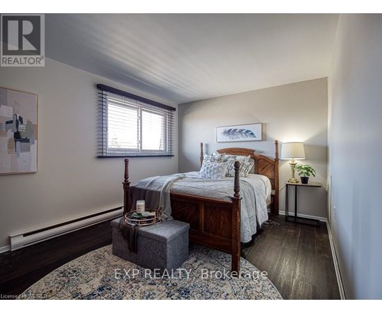 A bedroom with a bed, nightstand, and window.