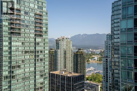 A cityscape with buildings and a body of water in the foreground.
