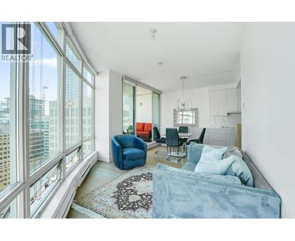 A living room with a blue couch and a rug with a heart design on it.