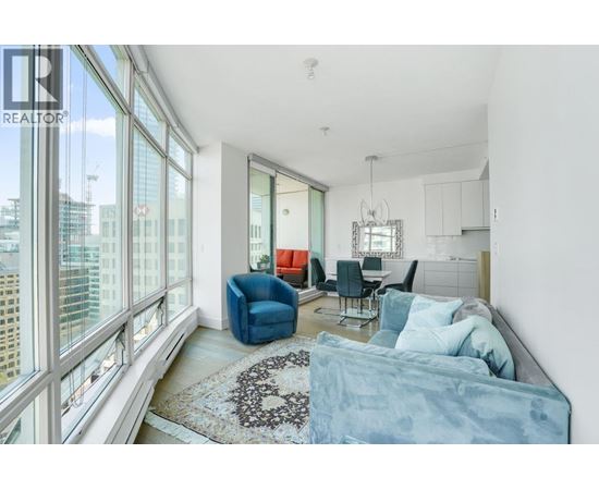 A living room with a blue couch and a rug with a heart design on it.