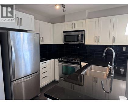 A kitchen with a stainless steel refrigerator, microwave, oven, and sink.