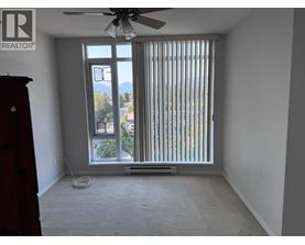 A room with a window covered by vertical blinds and a ceiling fan.