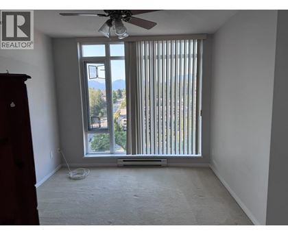 A room with a window covered by vertical blinds and a ceiling fan.