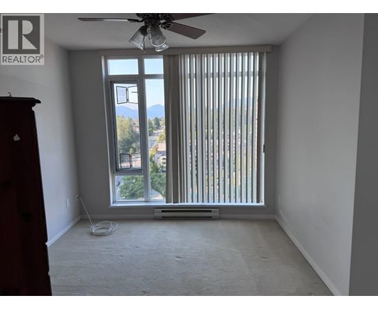 A room with a window covered by vertical blinds and a ceiling fan.