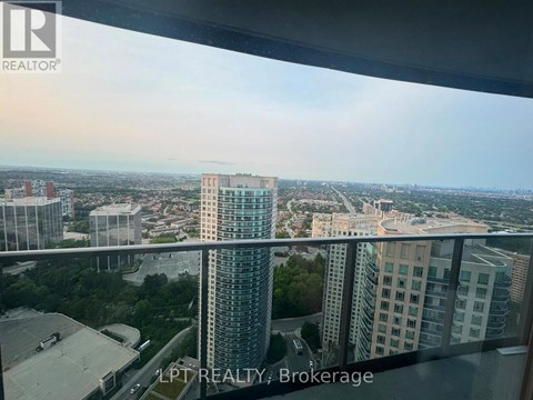 A cityscape viewed from a high-rise building with a glass balcony.