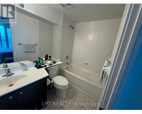 A bathroom with a white toilet, sink, and bathtub.