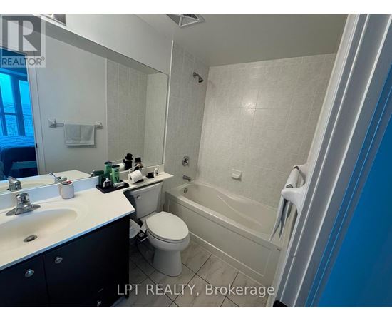 A bathroom with a white toilet, sink, and bathtub.